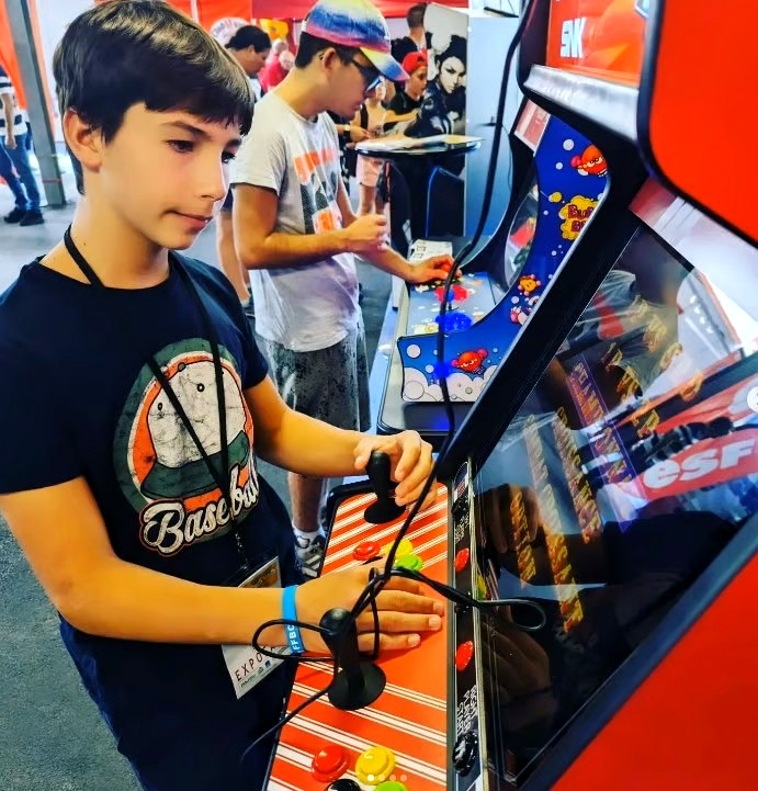Jeune joueur sur borne arcade Neo Geo