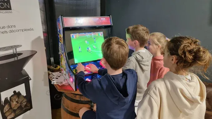 Des enfants partagent une partie sur une borne Arcade Pyrénées
