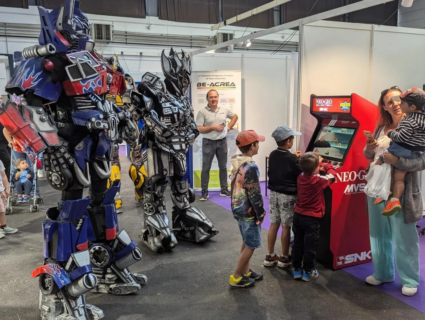 Familles et enfants devant une borne Neo Geo lors d’un salon